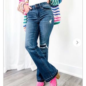 Judy Blue boot cut mid rise jeans with distressed hemming.
